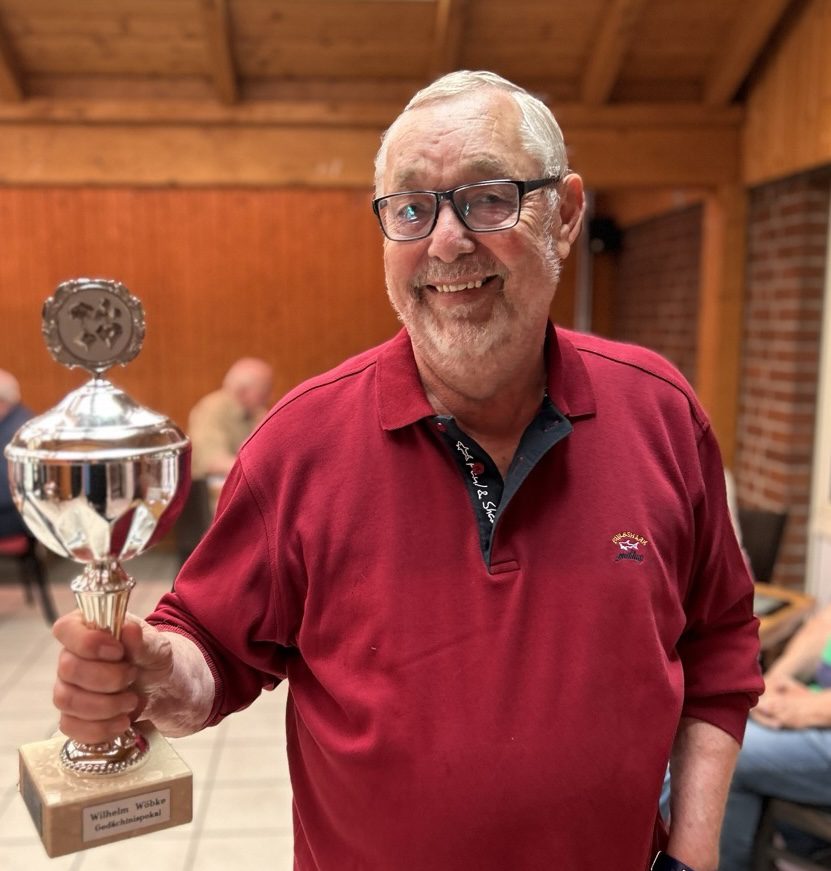 Peter hält stolz den Wilhelm Wöbcke Pokal